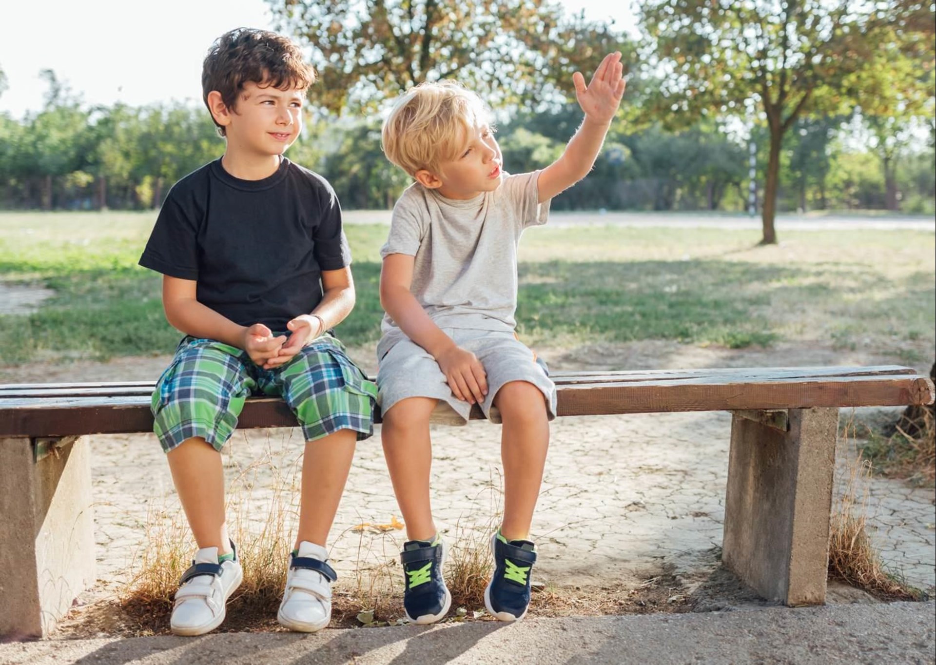 Zwei Jungen sitzen auf einer Bank.