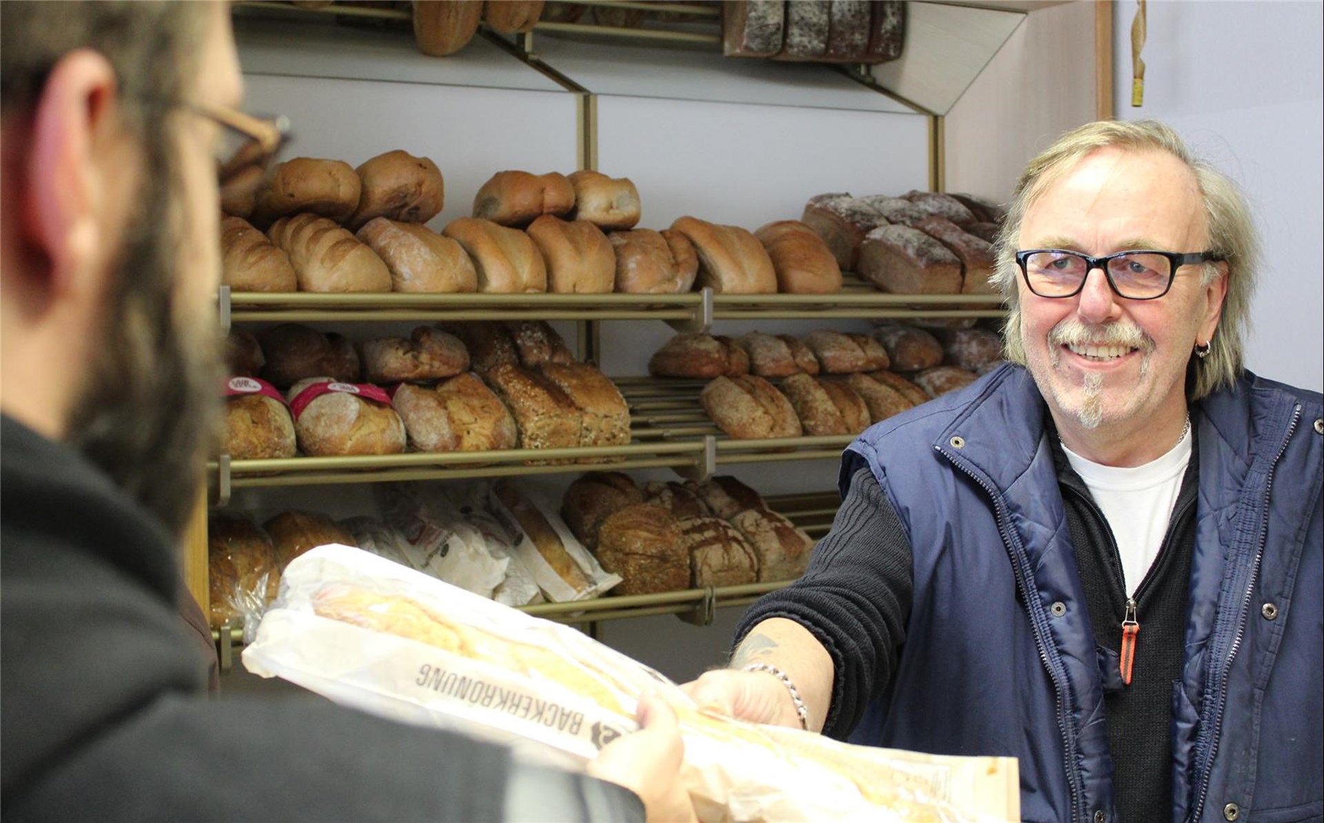 Ein ehrenamtlicher Mitarbeiter des Warenkorb bei der Ausgabe von Brot